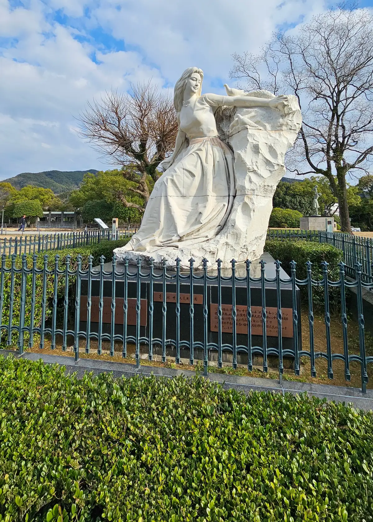 長崎和平公園裡中華人民共和國贈送的《乙女之像》，前方有樹籬與鐵欄杆隔開