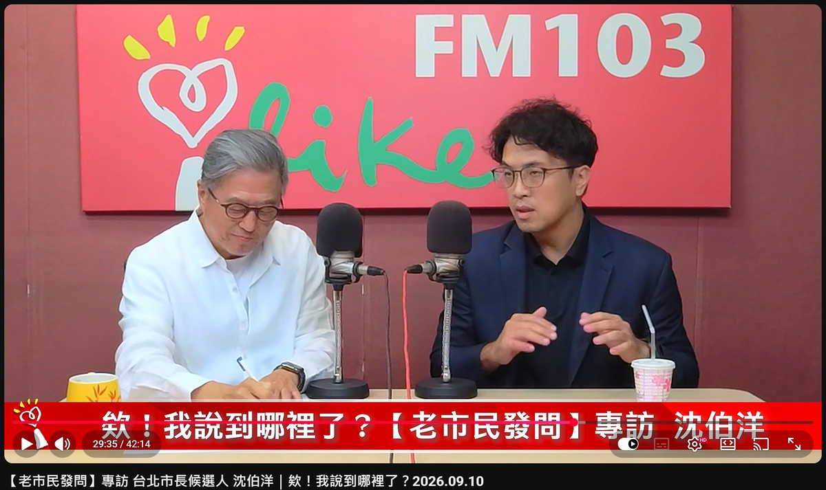 影片 29 分 35 秒處截圖：王偉忠低頭在紙上寫筆記，沈伯洋在一旁說明